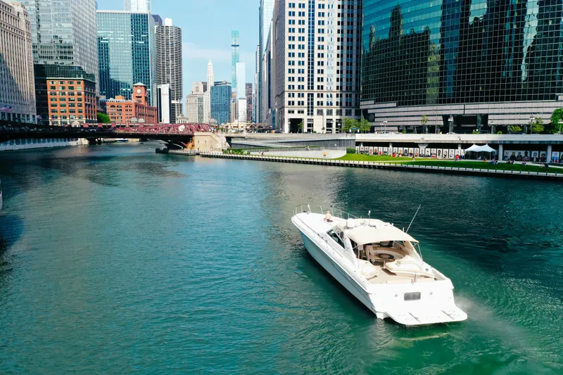  Yacht Photos Pics 1997 Sea Ray 630 Super Sun Sport yacht cruising in an urban river setting.