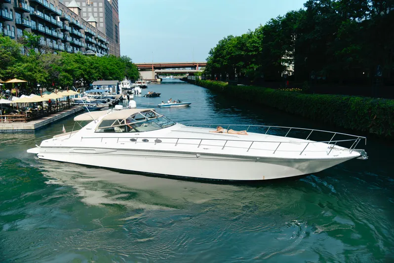  Yacht Photos Pics 1997 Sea Ray 630 Super Sun Sport yacht cruising on a scenic urban waterway.