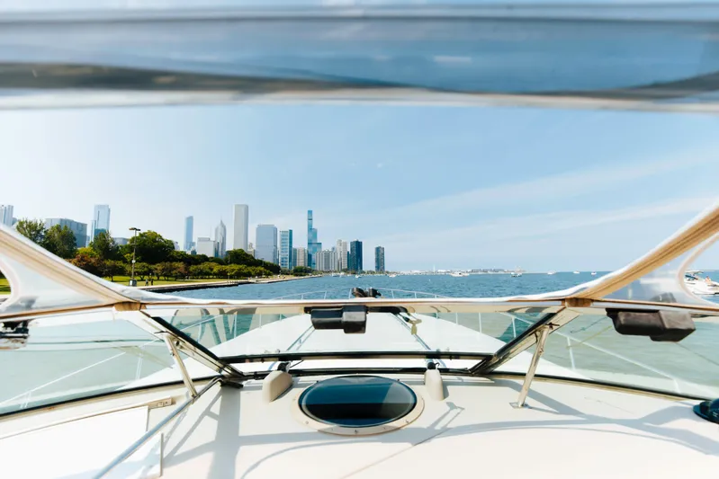  Yacht Photos Pics 1997 Sea Ray 630 Super Sun Sport yacht cruising near city skyline on a sunny day.