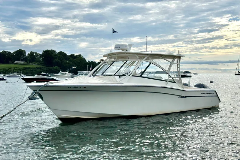 4850 Jg Yacht Photos Pics 2015 Grady White 335 Freedom boat anchored on a calm lake under a cloudy sky.