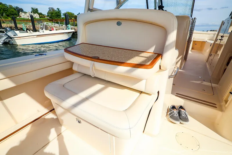 4850 Jg Yacht Photos Pics 2015 Grady White 335 Freedom boat interior with seating and table, docked by the water.