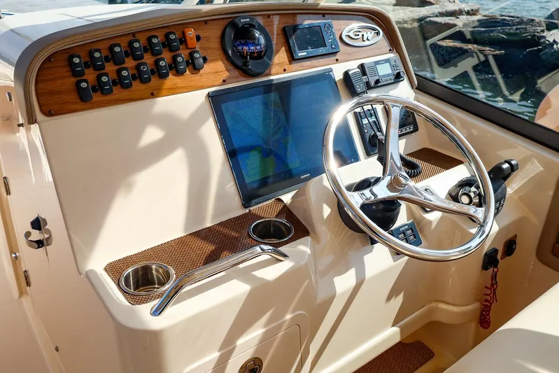 4850 Jg Yacht Photos Pics Control panel of a 2015 Grady White 335 Freedom boat with steering wheel and navigation screen.