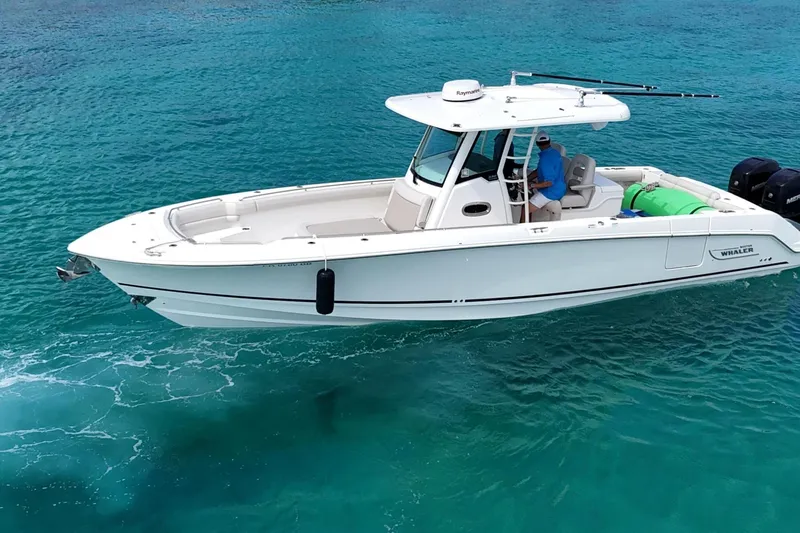  Yacht Photos Pics 2017 Boston Whaler 330 Outrage boat cruising on clear turquoise water.