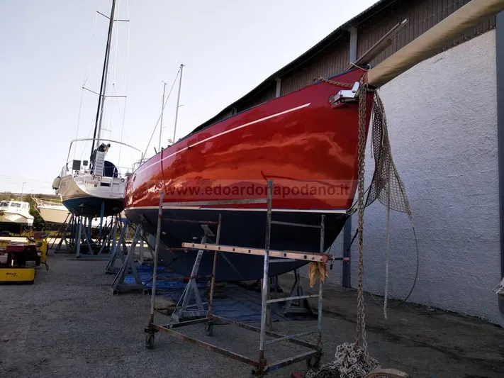  Yacht Photos Pics Red 1984 Classic Sciarrelli sailboat on stands in a boatyard.