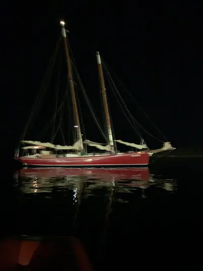  Yacht Photos Pics Classic 1984 Sciarrelli sailboat illuminated at night on calm waters.
