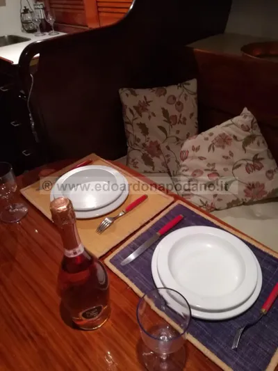  Yacht Photos Pics Elegant dining setup on 1984 Classic Sciarrelli yacht with wine and floral cushions.