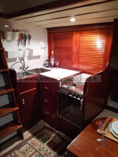  Yacht Photos Pics 1984 Classic Sciarrelli yacht interior kitchen with wooden cabinets and compact appliances.