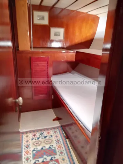 Yacht Photos Pics Cozy wooden cabin interior of 1984 Classic Sciarrelli yacht with bed and decorative rug.