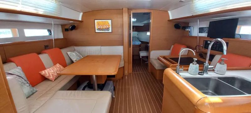 Alma Del Mar Yacht Photos Pics 2014 Jeanneau Sun Odyssey 469 interior with cozy seating, dining area, and modern kitchen.
