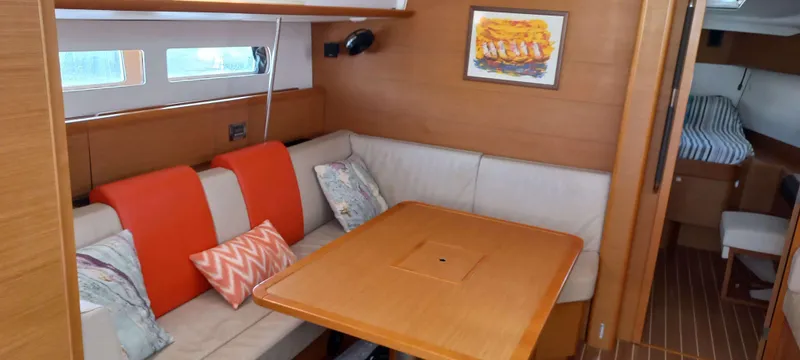 Alma Del Mar Yacht Photos Pics Interior of 2014 Jeanneau Sun Odyssey 469 yacht with cozy seating and dining area.