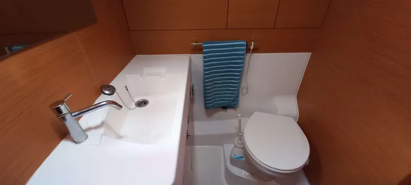 Alma Del Mar Yacht Photos Pics 2014 Jeanneau Sun Odyssey 469 bathroom with sink, toilet, and blue striped towel.