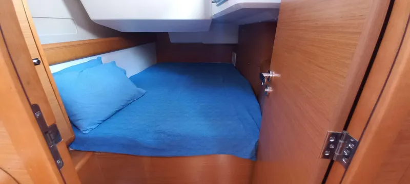 Alma Del Mar Yacht Photos Pics 2014 Jeanneau Sun Odyssey 469 cabin with blue bedding and wooden interior.