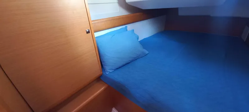 Alma Del Mar Yacht Photos Pics Cabin interior of 2014 Jeanneau Sun Odyssey 469 with blue bedding.
