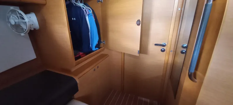 Alma Del Mar Yacht Photos Pics Interior cabin of 2014 Jeanneau Sun Odyssey 469 yacht with wooden closet and seating.