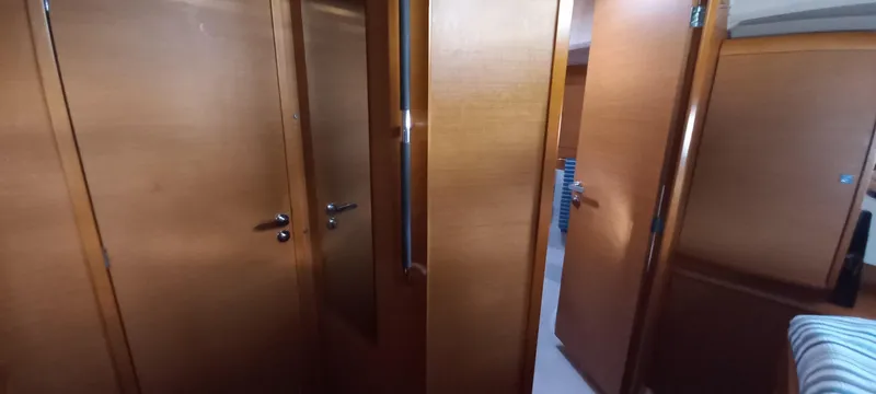 Alma Del Mar Yacht Photos Pics Interior view of 2014 Jeanneau Sun Odyssey 469 yacht with wooden doors and cozy cabin.