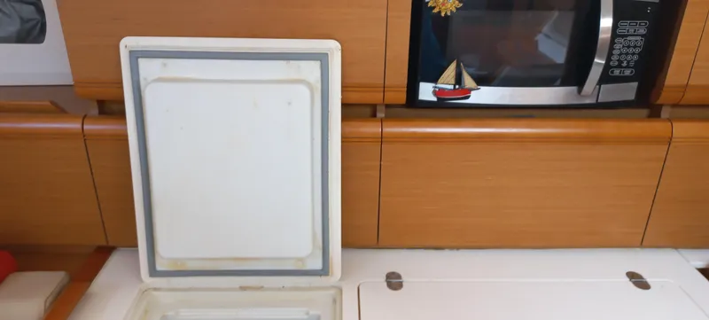 Alma Del Mar Yacht Photos Pics Interior of 2014 Jeanneau Sun Odyssey 469 yacht with microwave and storage compartment.