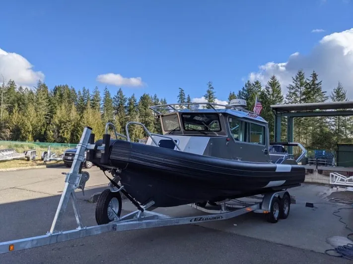  Yacht Photos Pics 2021 Life Proof 25 Full Cabin boat on trailer, parked outdoors under blue sky.