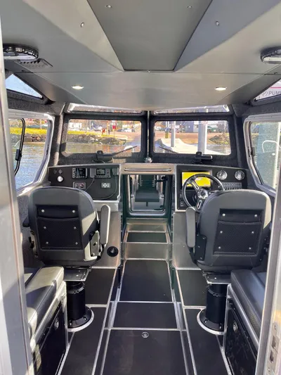  Yacht Photos Pics Interior of a 2021 Life Proof 25 Full Cabin boat, featuring modern seating and controls.