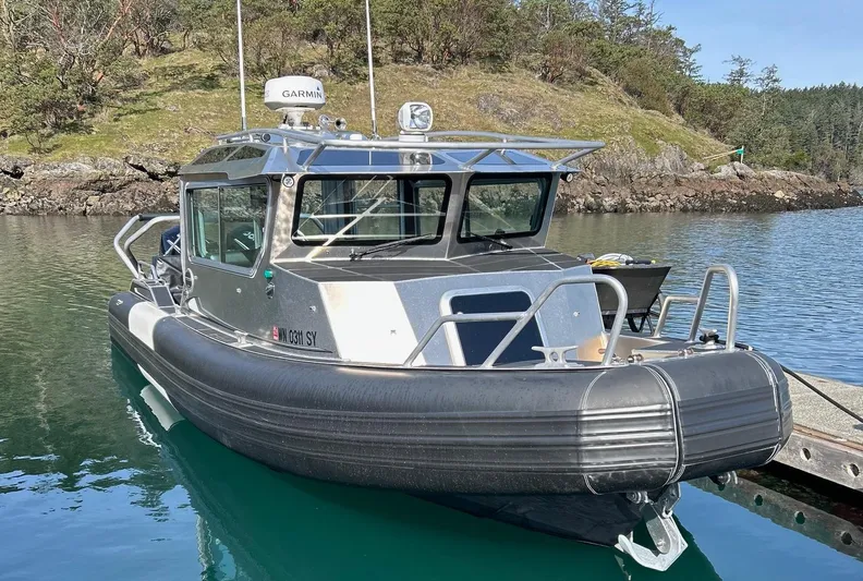  Yacht Photos Pics 2021 Life Proof 25 Full Cabin boat docked in a serene, wooded area.