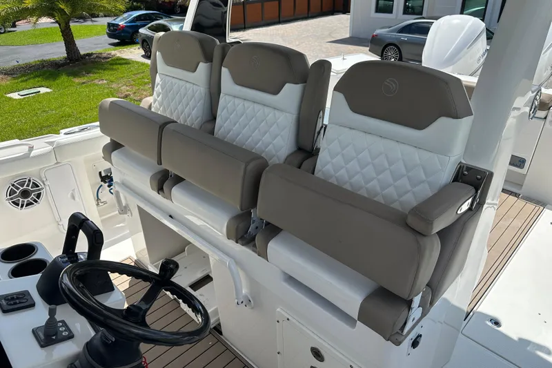  Yacht Photos Pics 2018 Edgewater 370 CC boat interior with three cushioned seats and steering wheel.