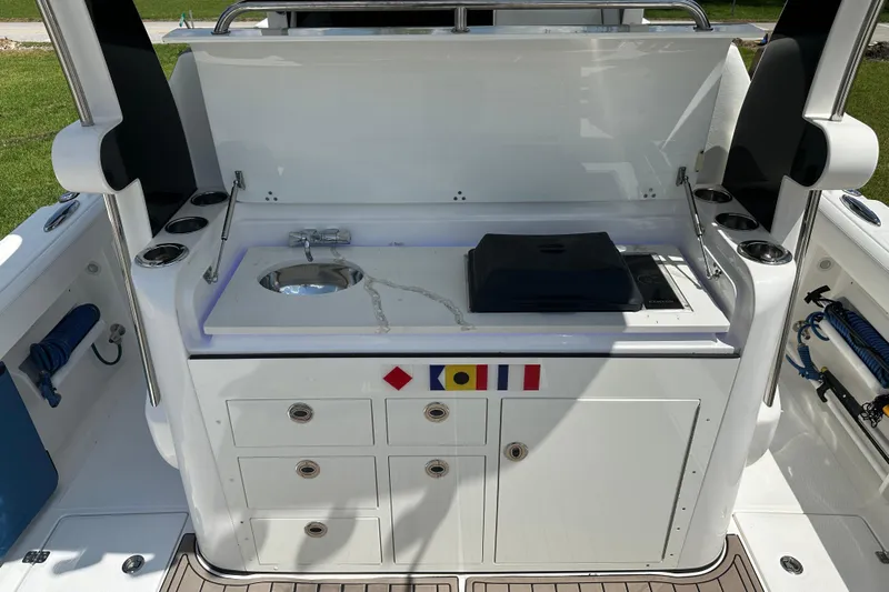  Yacht Photos Pics 2018 Edgewater 370 CC boat kitchen area with sink, stove, and storage cabinets.