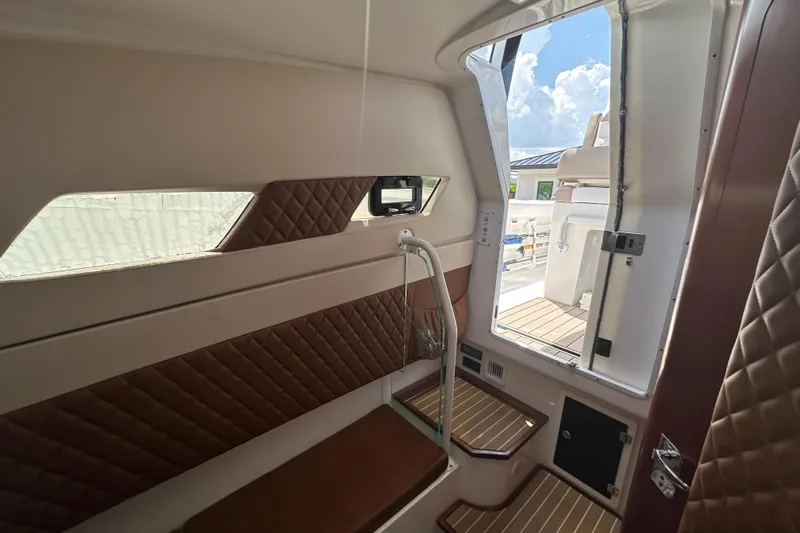  Yacht Photos Pics Interior view of 2018 Edgewater 370 CC boat cabin with seating and window.