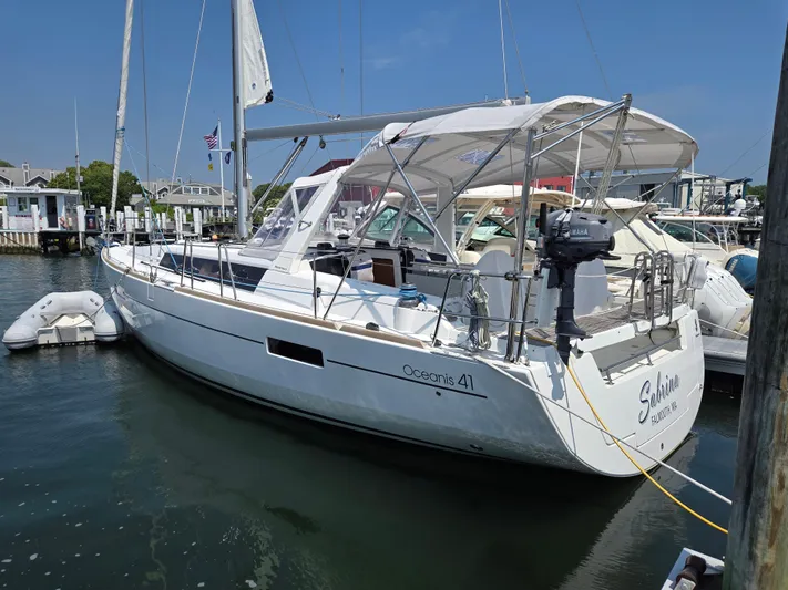 Sabrina Yacht Photos Pics 2013 Beneteau Oceanis 41 sailboat docked in a marina, featuring a sleek white design.