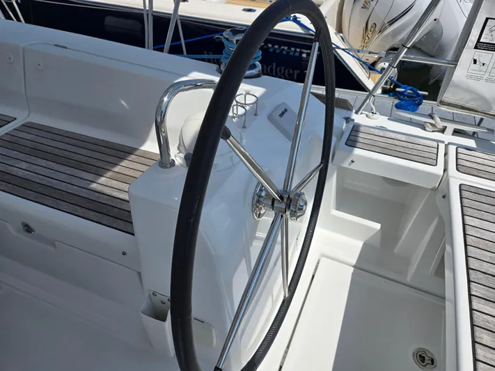 Sabrina Yacht Photos Pics Steering wheel of a 2013 Beneteau Oceanis 41 sailboat, featuring a sleek cockpit design.