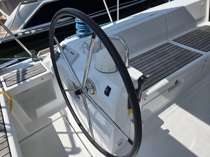 Sabrina Yacht Photos Pics Steering wheel of a 2013 Beneteau Oceanis 41 sailboat, featuring sleek design and modern controls.