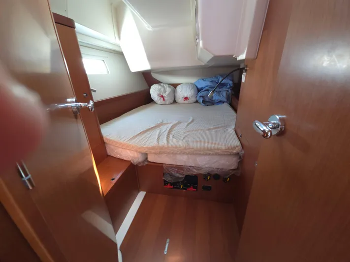 Sabrina Yacht Photos Pics Cozy cabin interior of 2013 Beneteau Oceanis 41 sailboat with bed and wooden finish.