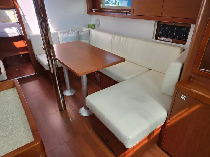 Sabrina Yacht Photos Pics Interior of 2013 Beneteau Oceanis 41 sailboat with white seating and wooden table.