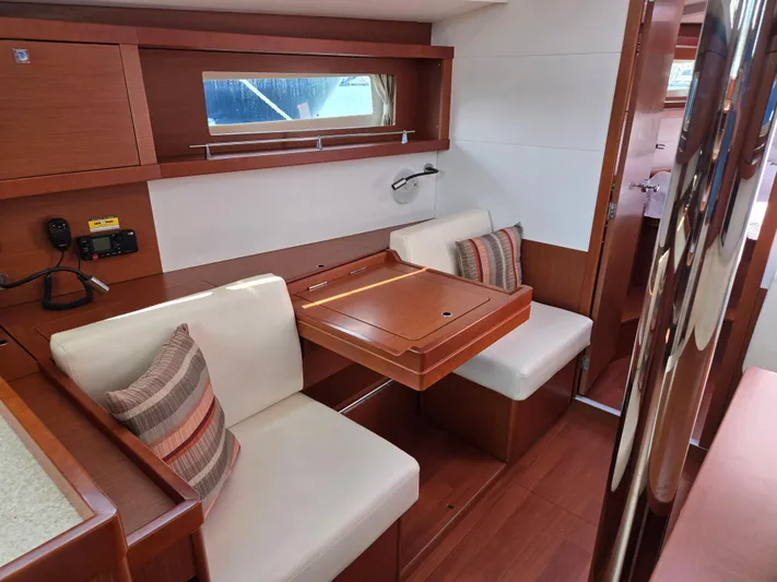 Sabrina Yacht Photos Pics Interior of 2013 Beneteau Oceanis 41 yacht with cozy seating and wooden table.