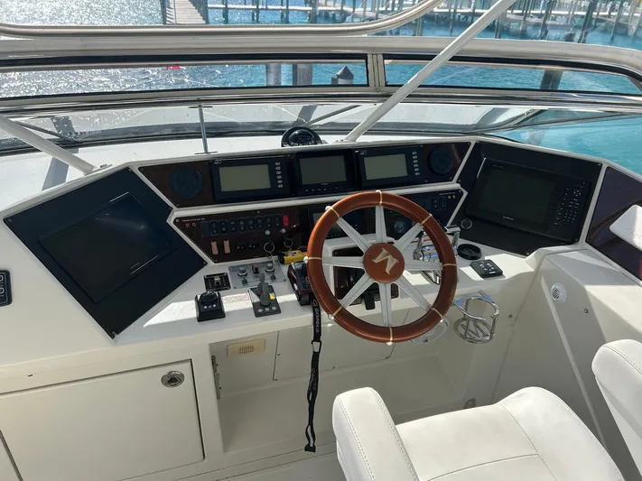 Sylvia Yacht Photos Pics 2006 Marquis 65 yacht helm with modern navigation equipment and wooden steering wheel.