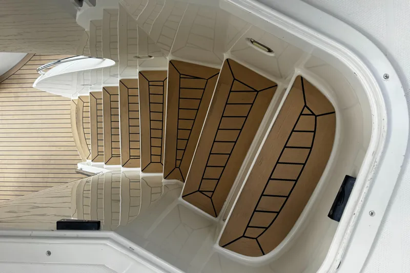 Sylvia Yacht Photos Pics Staircase on a 2006 Marquis 65 yacht with wooden steps and white railing.