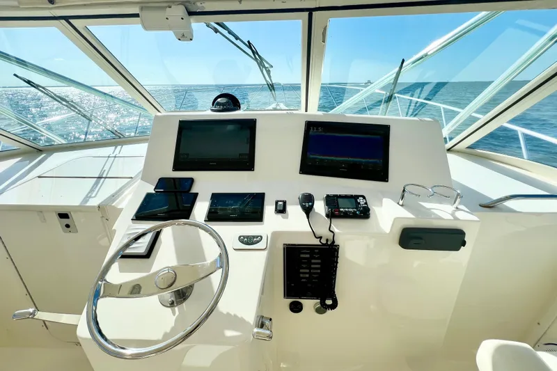 Yeah Buoy Yacht Photos Pics Helm of 2007 Albemarle 41 Express boat with navigation screens and steering wheel.