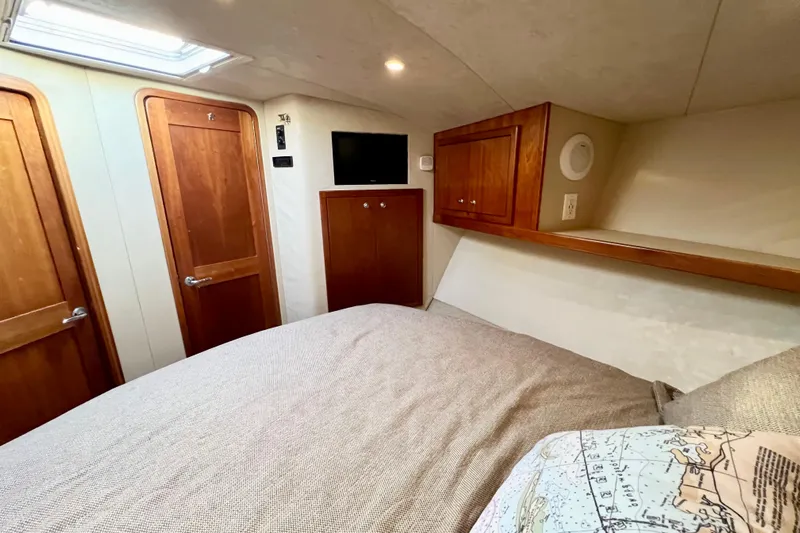 Yeah Buoy Yacht Photos Pics 2007 Albemarle 41 Express cabin interior with wood doors, bed, and wall-mounted TV.