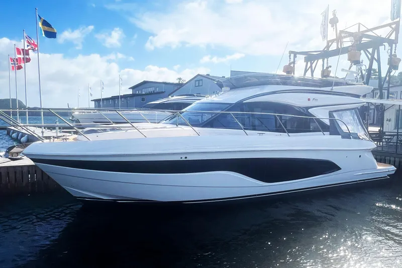 F45110 Yacht Photos Pics 2024 Princess F45 yacht docked at marina with flags in background.