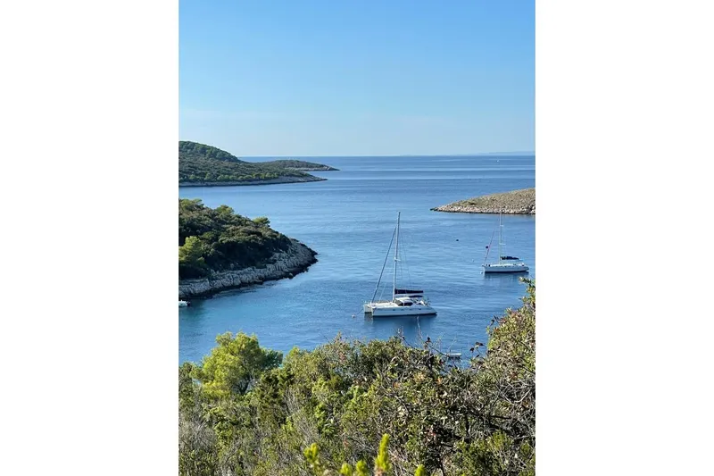 Southern Pearl Yacht Photos Pics Sailboats anchored in a serene bay, featuring a 2001 Privilege 435 catamaran.