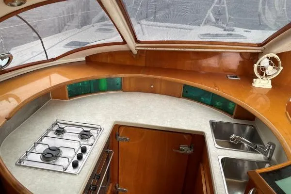 Southern Pearl Yacht Photos Pics Luxurious 2001 Privilege 435 yacht kitchen with stove, sink, and wooden cabinetry.