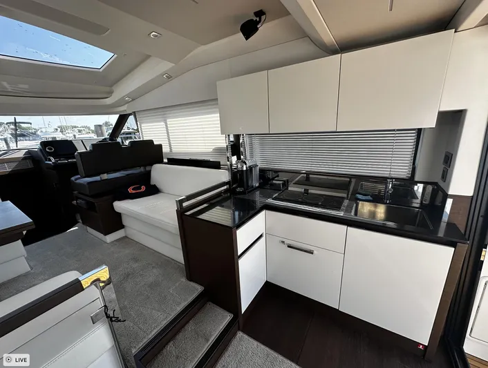  Yacht Photos Pics Interior of 2018 Prestige 460S Coupé yacht with modern kitchen and seating area.