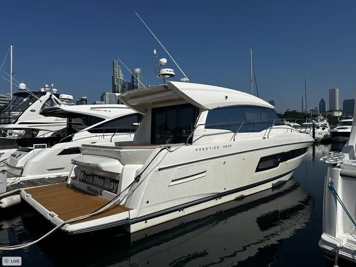  Yacht Photos Pics 2018 Prestige 460S Coupé yacht docked at marina, clear sky, city skyline in background.