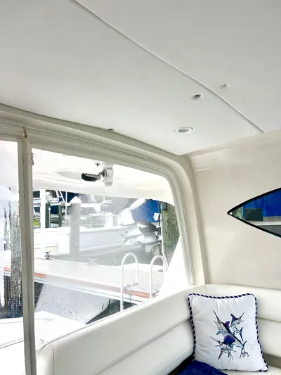 Reel Life Yacht Photos Pics Interior of 2015 Jupiter 41SB boat with white seating and decorative pillow.