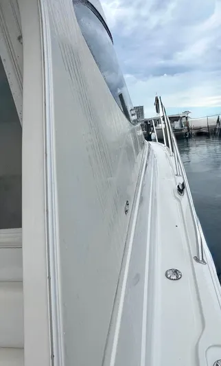 Reel Life Yacht Photos Pics Side view of a 2015 Jupiter 41SB boat docked by calm waters.