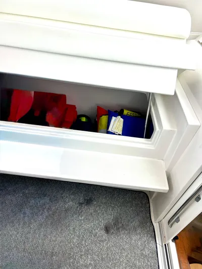 Reel Life Yacht Photos Pics Storage compartment on a 2015 Jupiter 41SB boat, containing various items.