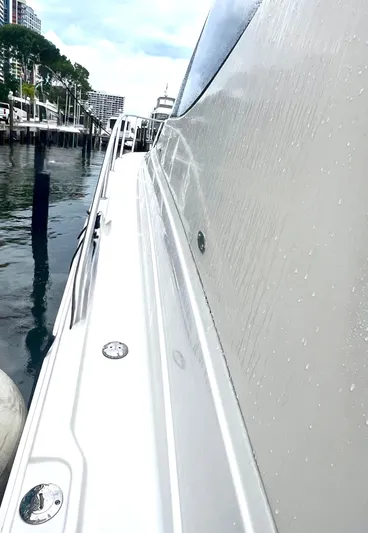 Reel Life Yacht Photos Pics 2015 Jupiter 41SB yacht side view at marina, showcasing sleek design and water reflections.
