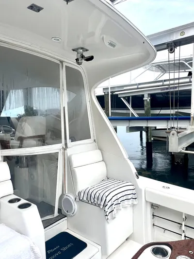 Reel Life Yacht Photos Pics 2015 Jupiter 41SB boat interior with white seating and striped towel, docked at marina.