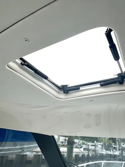 Reel Life Yacht Photos Pics Sunroof of 2015 Jupiter 41SB boat, showcasing open hatch and hydraulic supports.