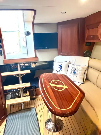 Reel Life Yacht Photos Pics Luxurious interior of 2015 Jupiter 41SB yacht with wooden table and comfortable seating.