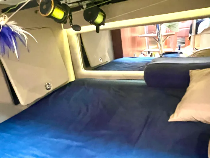 Reel Life Yacht Photos Pics Cozy cabin interior of 2015 Jupiter 41SB with blue bedding and ambient lighting.