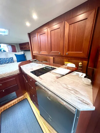 Reel Life Yacht Photos Pics Luxurious 2015 Jupiter 41SB yacht interior with modern kitchen and cozy sleeping area.